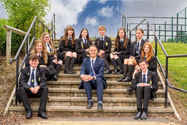 Head teacher and students sitting on steps